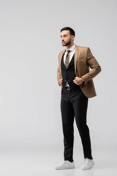 Full length view of stylish muslim man looking away while posing on grey — Stock Photo