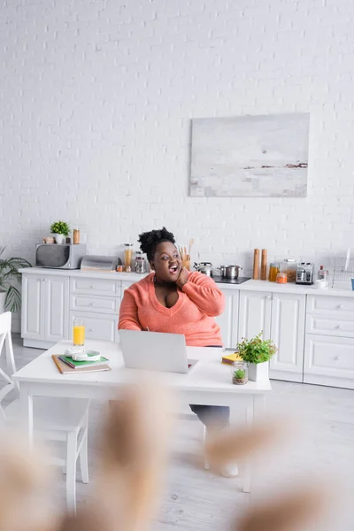 Amazed african american plus size freelancer working from home — Stock Photo