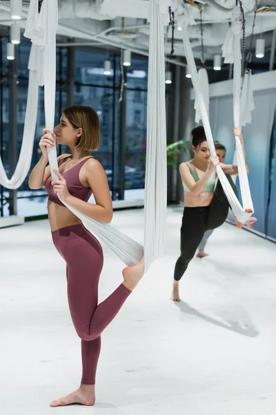 Addestramento giovane donna in forma con amaca appesa durante lo yoga a mosca — Foto stock