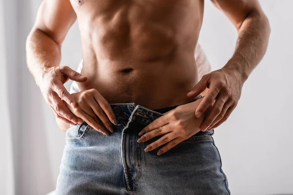 Cropped view of woman taking off jeans from sexy man — Stock Photo