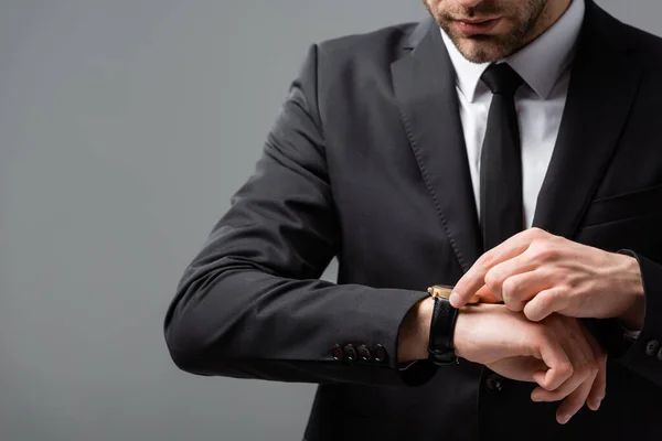 Cropped view of businessman checking time on wristwatch isolated on grey — Stock Photo