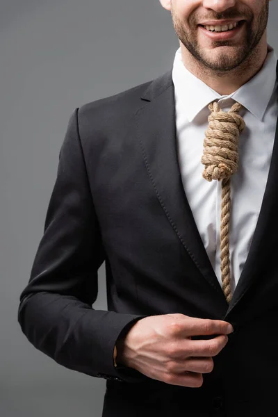 Vista cortada de empresário sorridente com corda em vez de gravata isolada em cinza — Fotografia de Stock