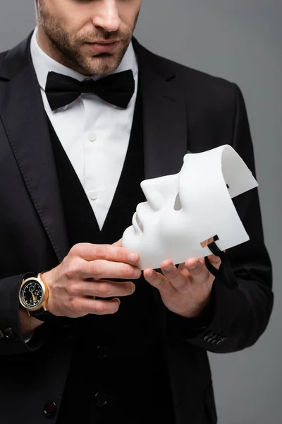 Partial view of young businessman holding face mask isolated on grey — Stock Photo