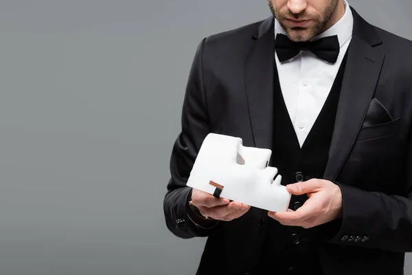 Partial view of elegant businessman holding face mask isolated on grey — Stock Photo