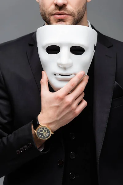 Vue recadrée du chef d'entreprise exploitant masque facial isolé sur gris — Photo de stock