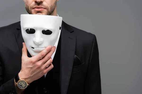 Cropped view of businessman holding face mask isolated on grey — Stock Photo