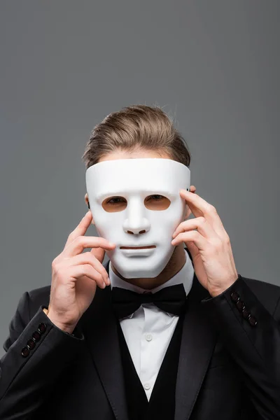 Jeune homme d'affaires cachant visage avec masque isolé sur gris — Photo de stock