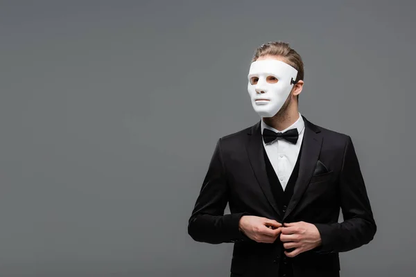 Hombre de negocios en mascarilla mascarilla abotonamiento chaqueta aislado en gris - foto de stock