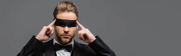 Elegant businessman touching blindfold isolated on grey, banner — Stock Photo