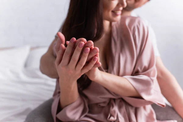 Cropped view of adult couple on blurred background holding hands — Stock Photo