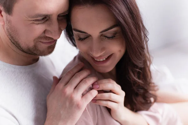 Smiling adult couple touching hands at home — Stock Photo