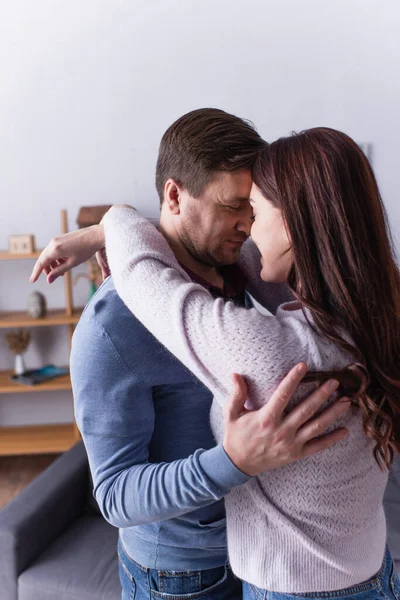 Homem abraçando morena esposa em casa — Fotografia de Stock