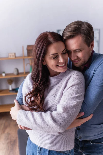 Homem adulto abraçando esposa positiva em casa — Fotografia de Stock