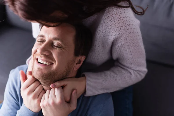 Mujer en primer plano borrosa abrazando al marido y tomándose de la mano - foto de stock