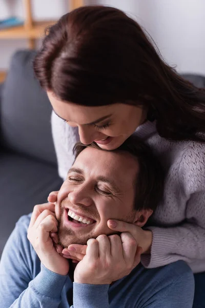 Smiling woman touching face of cheerful husband — Stock Photo