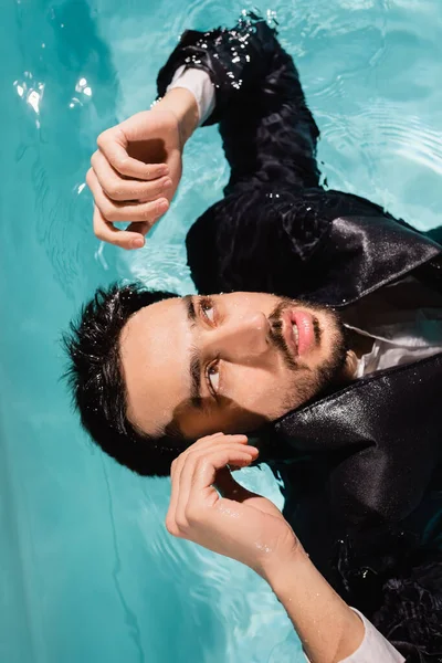 Homem de negócios árabe de terno olhando para longe na piscina — Fotografia de Stock
