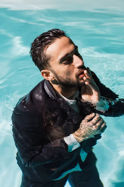 Muslim businessman touching lips in swimming pool — Stock Photo