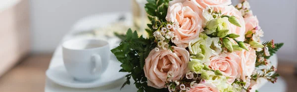 Selective focus of wedding bouquet near coffee cup on blurred background, banner — Stock Photo