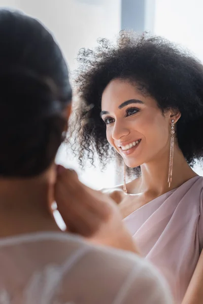 Felice donna afro-americana guardando la sposa in primo piano offuscata — Foto stock