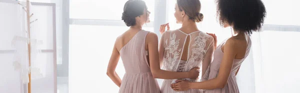 Back view of interracial women hugging young bride, banner — Stock Photo