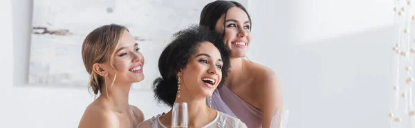 Excité afro-américaine mariée regardant loin près des amis heureux, bannière — Photo de stock