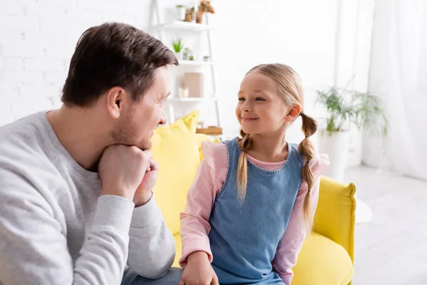 Adult man talking to cheerful daughter at home — Stock Photo