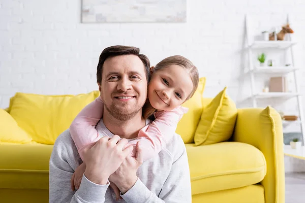 Joyeux papa avec fille souriant à la caméra à la maison — Photo de stock