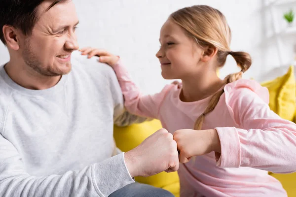 Excited man doing fist bump with daughter on blurred background — Stock Photo