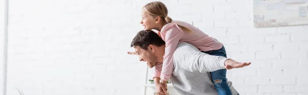 Vista lateral do homem piggybacking excitado filha em casa, banner — Fotografia de Stock