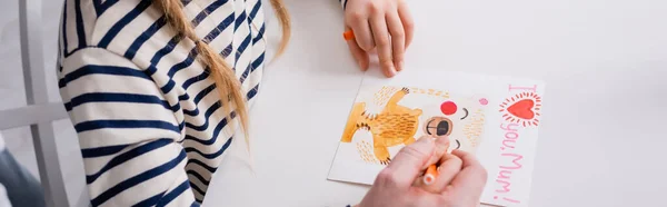 Vista parcial de padre e hija dibujando tarjetas de día de las madres con te quiero mamá letras, pancarta - foto de stock