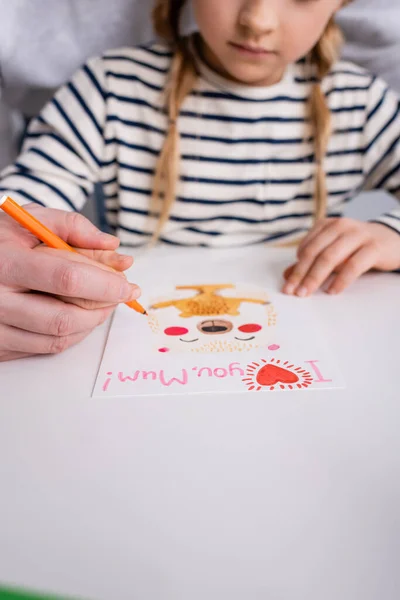 Vista ritagliata del padre aiutare figlia disegno biglietto di auguri con ti amo mamma lettering, sfondo sfocato — Foto stock