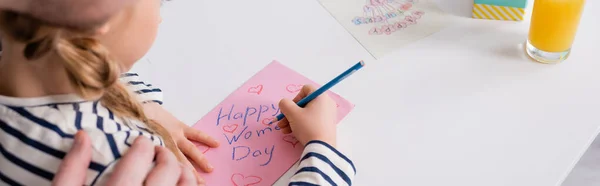 Partial view of man touching shoulder of daughter drawing happy womens day card, blurred foreground, banner — Stock Photo