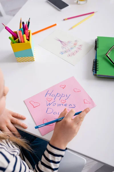 Cropped view of child drawing happy womens day card on blurred foreground — Stock Photo