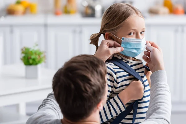 Papà regolazione maschera medica sulla figlia, primo piano sfocato — Foto stock