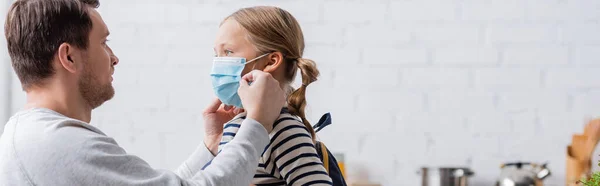 Pai colocando máscara médica na filha, banner — Fotografia de Stock