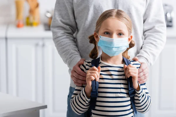 Schoolgirl in protective mask looking at camera near dad — Stock Photo