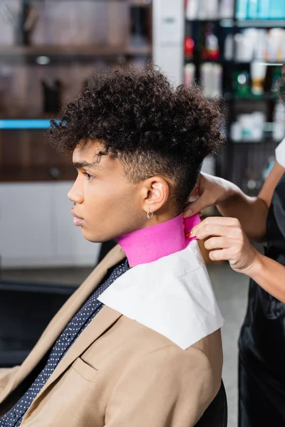 African american hairdresser using collar paper on client in salon — Stock Photo