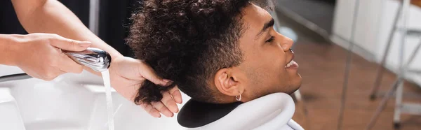 Souriant homme afro-américain près du coiffeur et évier, bannière — Photo de stock