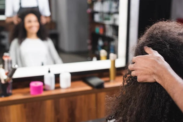 Африканський американський перукар торкається волосся жінки в салоні. — стокове фото