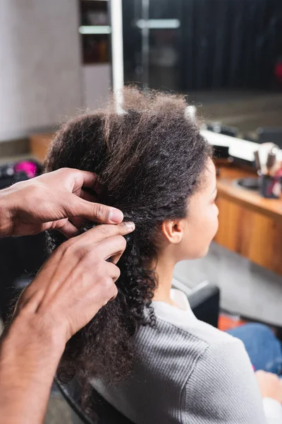 Acconciatore afroamericano che tocca capelli di donna in salone — Foto stock