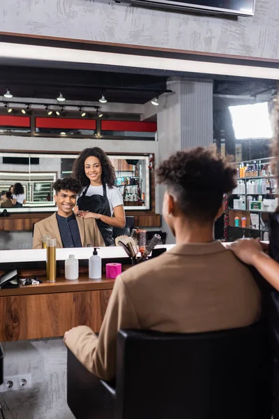 Souriant afro-américain coiffeur étreignant client dans le salon — Photo de stock