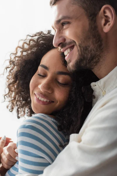 Glückliches multiethnisches Paar beim Umarmen zu Hause — Stockfoto