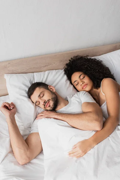 Visão de alto ângulo de casal multiétnico dormindo na cama — Fotografia de Stock