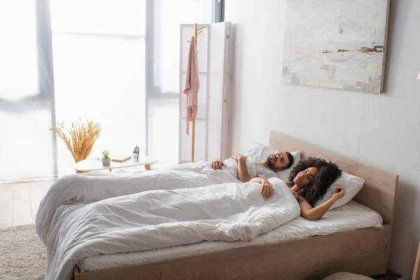 Multiethnic couple sleeping together in bed — Stock Photo
