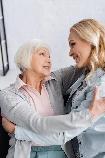 Seniorin umarmt Tochter im Wohnzimmer — Stockfoto