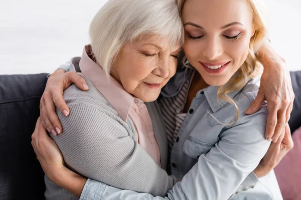 Frau mit geschlossenen Augen umarmt Seniorin — Stockfoto