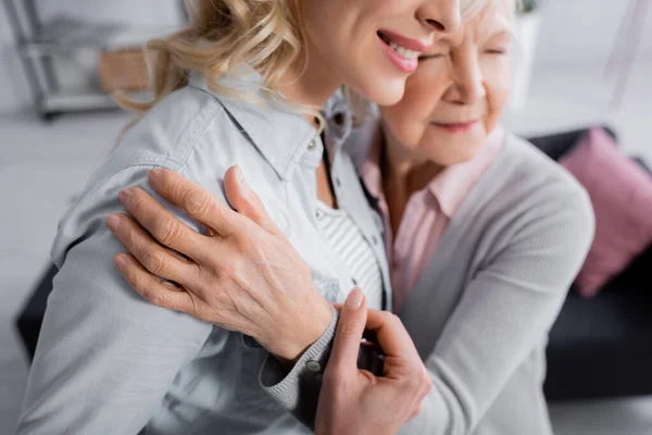 Verschwommene Seniorin umarmt lächelnde Tochter — Stockfoto