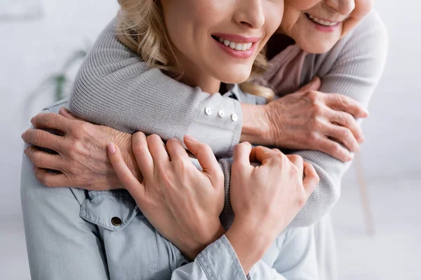 Vista ritagliata della figlia che abbraccia i genitori anziani — Foto stock