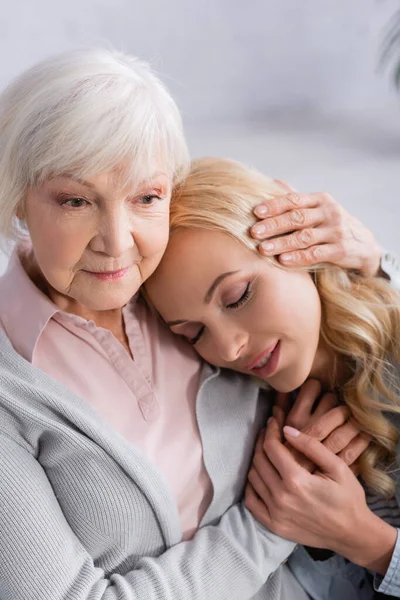 Seniorin umarmt und hält Hand ihrer erwachsenen Tochter — Stockfoto