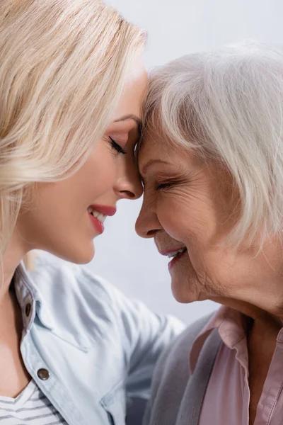 Vista lateral de mulher sorridente e mãe de pé com os olhos fechados — Fotografia de Stock